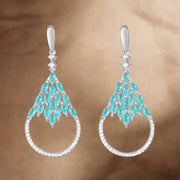 A pair of sterling silver earrings with blue colored gemstones, likely to be cubic zirconia, set in a open circular frame design.